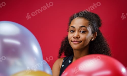Preview: Young teenager girl in a studio on red background, looking at camera.