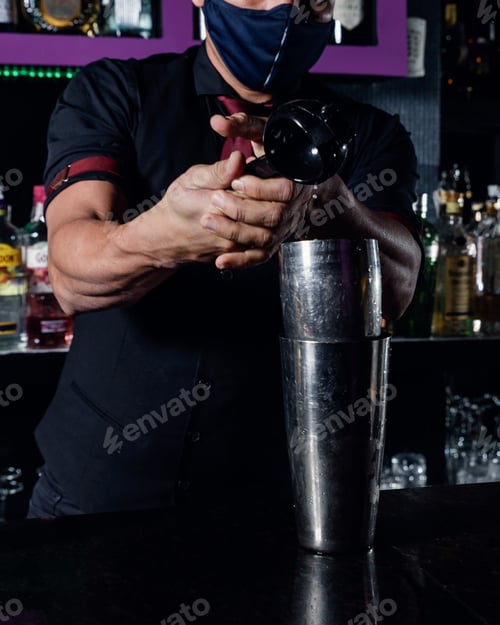 Preview: A young professional bartender prepares cocktails for his clients at work. profession concept