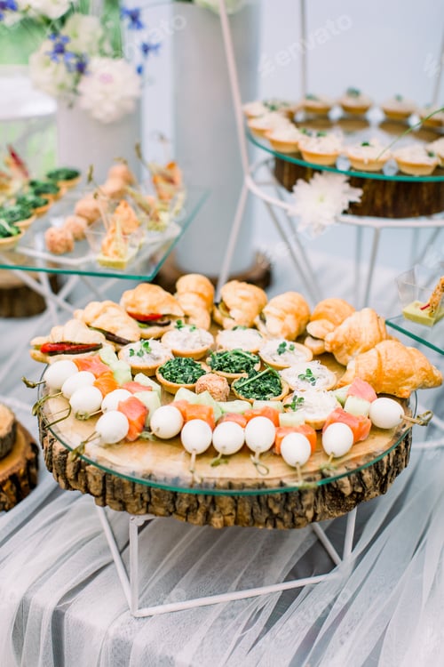 Preview: Beautifully decorated catering banquet table with different food snacks and appetizers on corporate