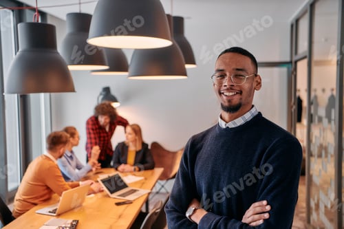 Preview: Startup Leadership: African American Businessman in Modern Office with Colleagues in Background.