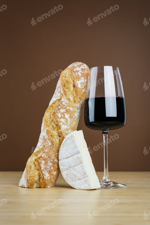 Preview: Minimalistic composition of a glass of red wine, a baguette, and camembert cheese.