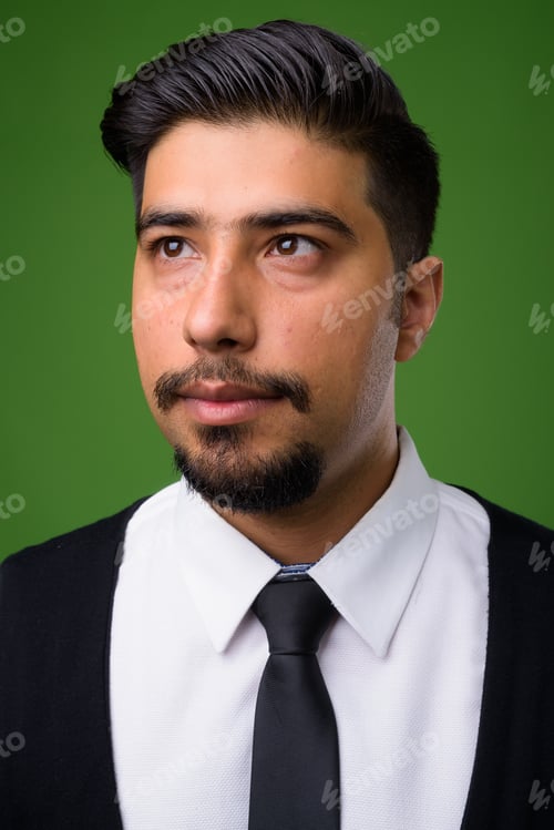 Preview: Young bearded Iranian businessman against green background