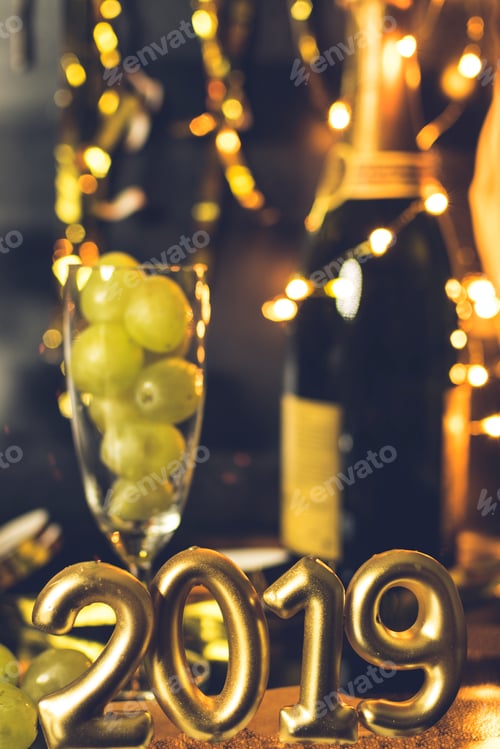 Preview: End of the year concept. Glass of champagne with grapes inside