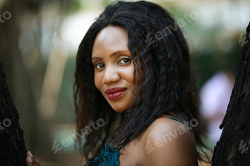 Preview: Cheerful young Afro American woman standing in tropical garden.