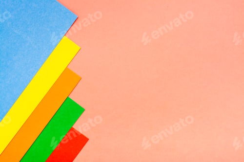 Preview: Sheets of colored cardboard lie in a row on a red background. Top view. Copy space