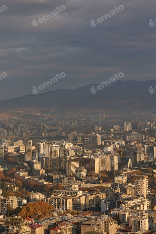 Preview: Scenic view of Tbilisi surrounded by majestic mountains in the distance at sunrise in Georgia