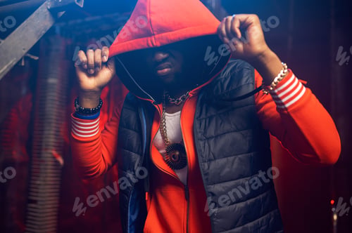 Preview: Rapper in red hoodie poses in grunge studio