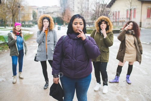 Preview: group of young multiracial women smoking cigarette in the street