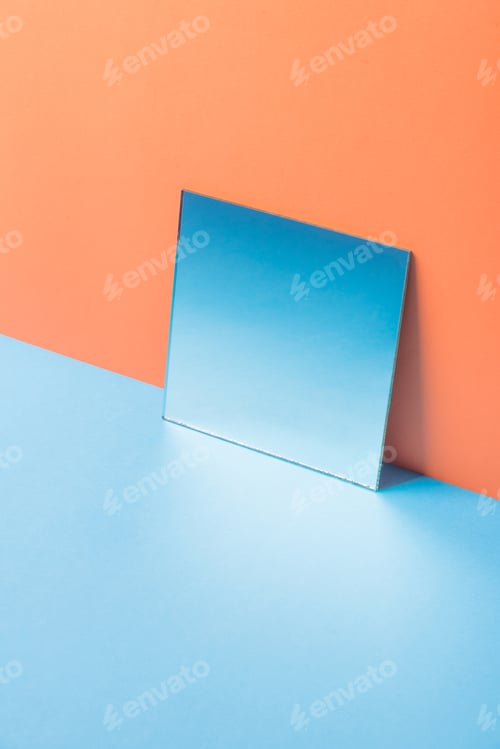 Preview: Mirror on blue table isolated over orange background