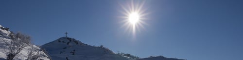 Preview: Banner 4x1 with mountain peaks, bright midday sun in clear blue sky. Guiding cross on peak