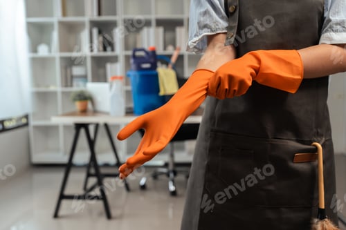 Preview: Female housekeeper smile and wearing glove, preparing to clean office