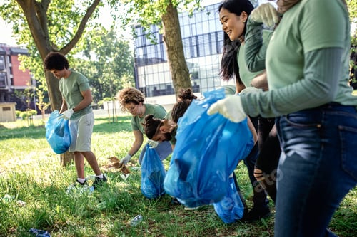 Preview: Multiethnic group of volunteers with garbage bags cleaning city park.