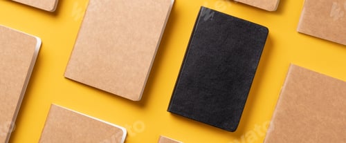 Preview: Top view of notebook align in pattern on yellow table