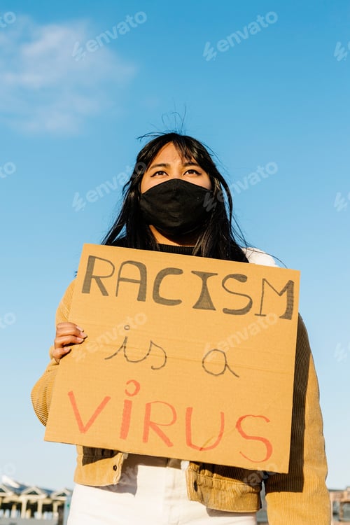 Preview: Vietnamese young student in face mask protesting during stop asian hate campaign - Focus on woman