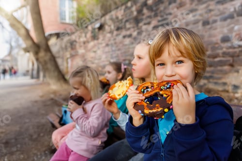Preview: Portrait group happy funny playful blond children enjoy eating pretzels chocolate toppings at city
