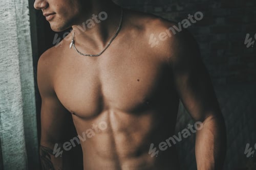 Preview: One beautiful fit male young body in dark shadow at home. Fitness and muscles healthy lifestyle
