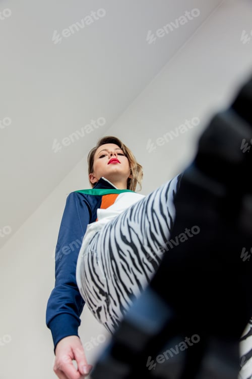 Preview: Young girl in zebra pants and 90s style jacket stepping on the camera with hir bootonith hir booton