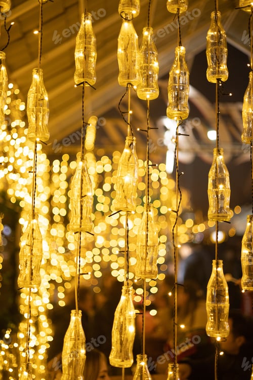 Preview: an artistic hanging display of bottles filled with holiday lights with lots of lights inside