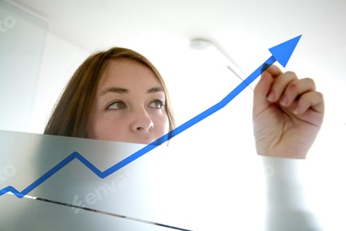 Preview: Business Woman Drawing A Graph On A Glass Window In An Office - Focus Is On Graph