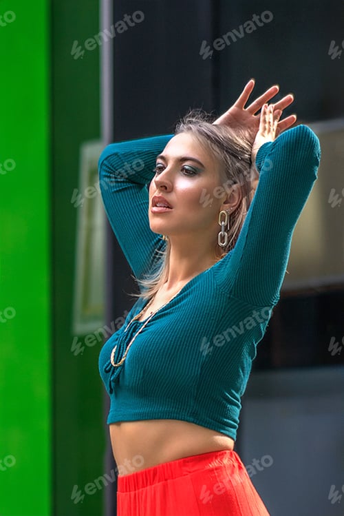 Preview: A woman in bright clothes, a red skirt and a green longsleeve is standing in a business center