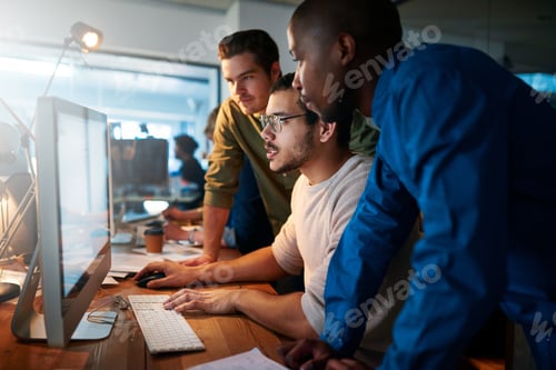 Preview: Shot of a team of young businesspeople working late in the office