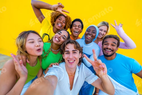 Preview: Multi-ethnic and gender friends gesturing success while taking a selfie