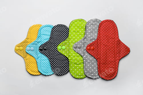 Preview: Many reusable cloth menstrual pads on white background, flat lay
