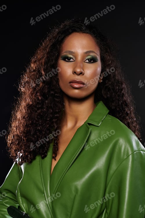 Preview: Striking woman in bold green outfit exudes confidence and elegance in stunning studio lighting