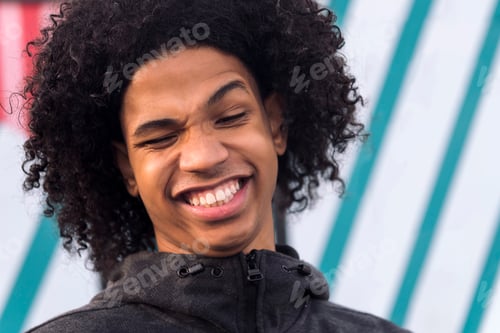 Preview: funny male teenager with curly hair laughing happy