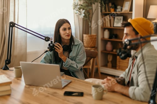 Preview: Content creators recording podcast in home studio using professional microphone and laptop