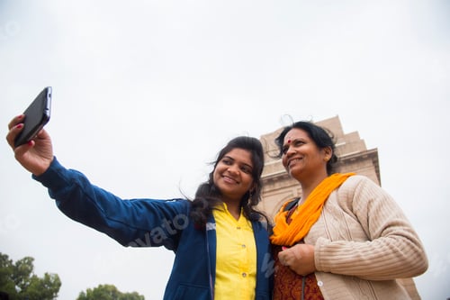 Preview: Tourist taking selfie with smart phone in front of India Gate, Delhi, India.