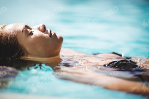 Preview: Peaceful blonde floating in the pool with eyes closed