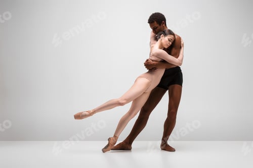 Preview: Couple of ballet dancers posing over gray background