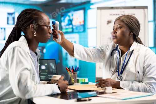 Preview: Black medic measuring the temperature during routine checkup at the clinic