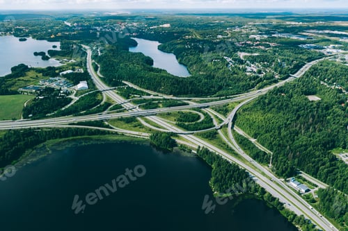 Preview: Aerial view of highway and overpass road with green woods and blue lakes in Finland.