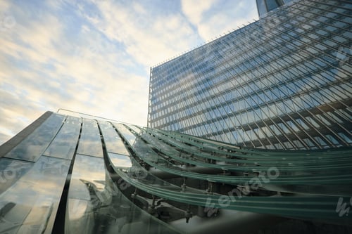 Preview: Modern Glass Office Building Reflecting Sky during Early Morning Sunrise