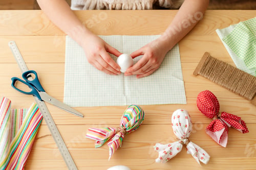 Preview: A girl at home makes Easter egg decorations in the shape of a rabbit from fabric.