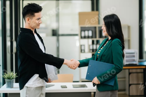 Preview: Business partnership handshake concept.Photo two coworkers handshaking process.Successful