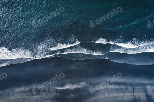 Preview: Moody atlantic ocean wave on black sand beach in summer at Iceland