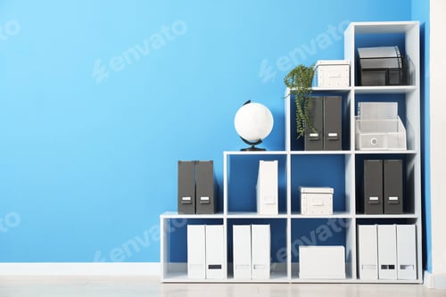 Preview: Shelving unit with folders and globe near light blue wall indoors, space for text