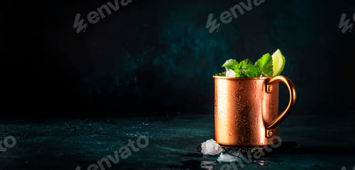 Preview: Moscow mule alcoholic cocktail in copper mug with lime, ginger beer, vodka and mint. Blue table