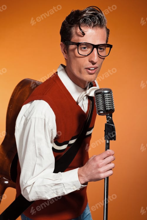 Preview: Retro Fifties Style Rock And Roll Singer With Vintage Microphone. Studio Shot.