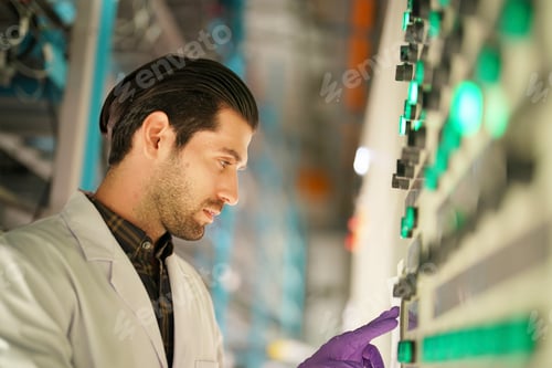 Preview: Scientist examining control panel with glowing buttons in laboratory setting