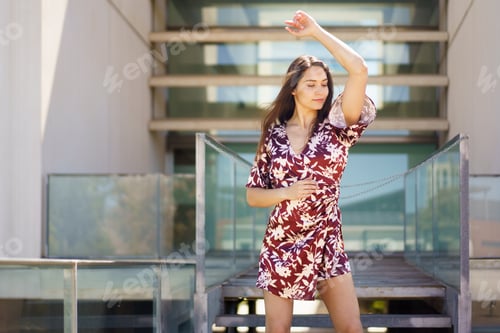 Preview: Energetic woman dancing a choreography wearing summer dress outdoors