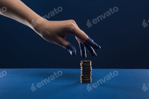 Preview: cropped view of female hand with painted fingers touching coins isolated on blue
