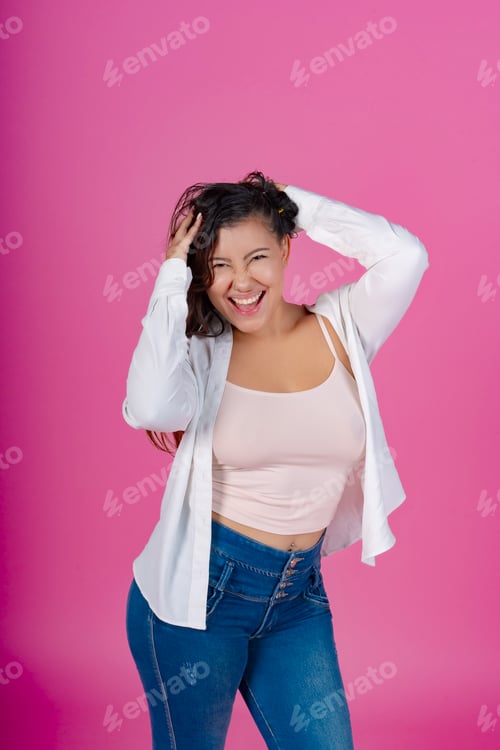 Preview: Happy Woman Laughing with Hands in Hair on Pink