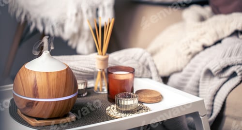 Preview: A cozy composition with an aroma diffuser and candles in a home interior.