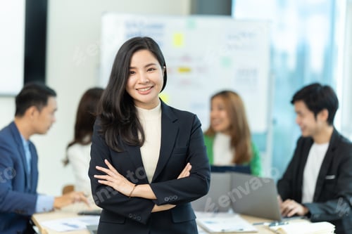 Preview: Business people showing team work while working in board room in office interior.