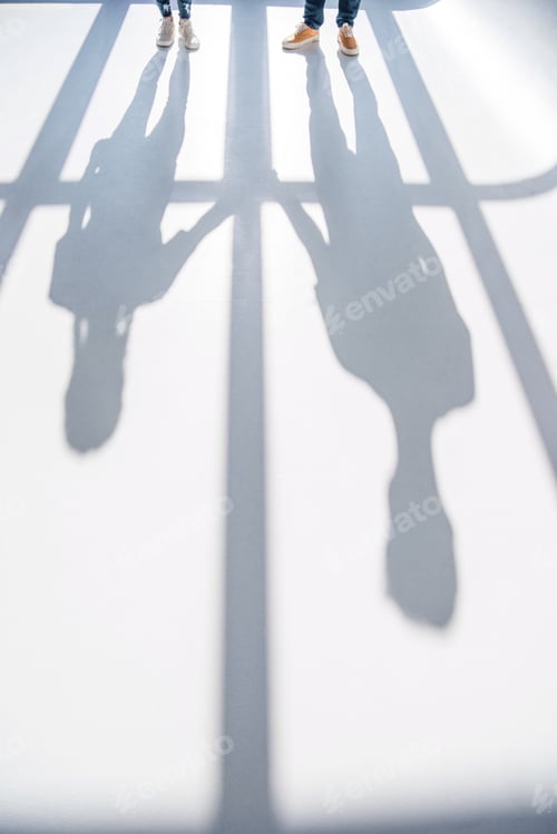 Preview: cropped shot of young standing together and shadows on grey