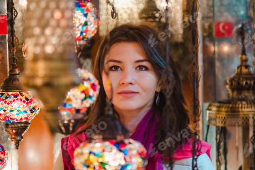 Preview: Closeup of beautiful woman looking at Turkish lamps for sale in the Grand Bazaar Istanbul, Turkey